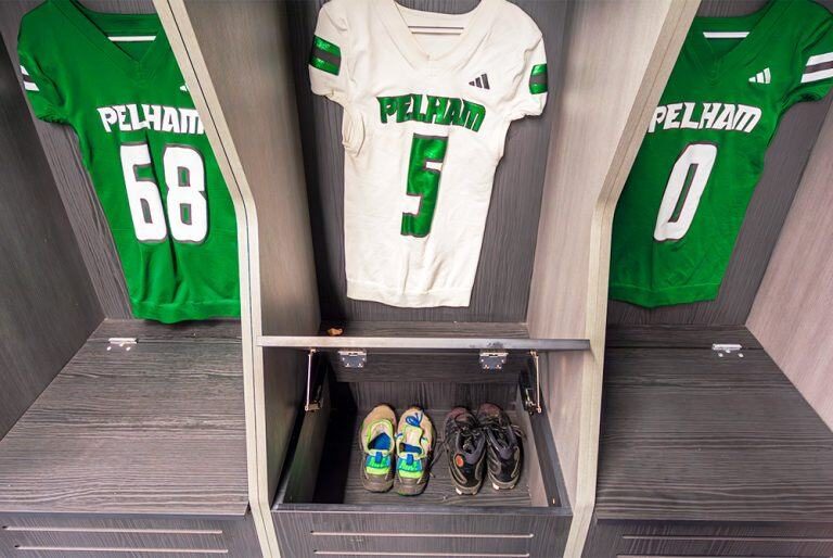 A locker shown open on its piano hinge over a vented shoe cubby